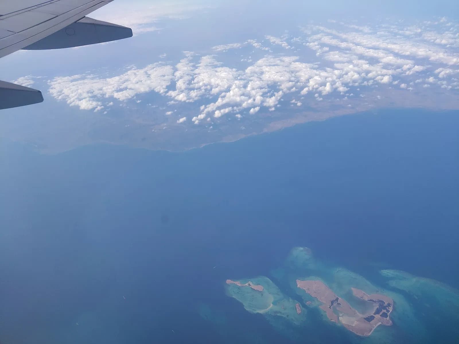 Vista del cielo y el mar desde la ventana de un avión